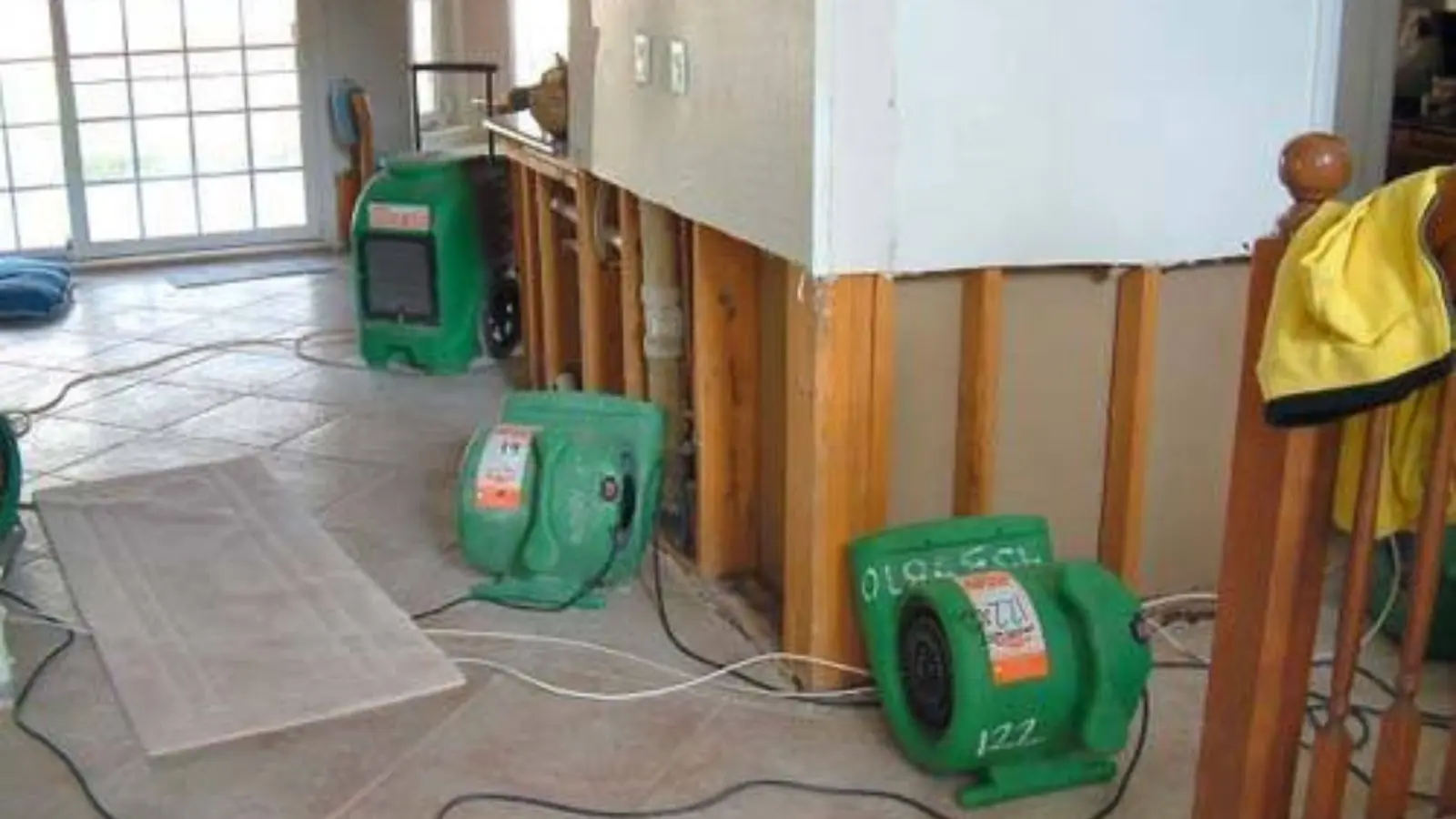 Restoration crew drying a water-damaged living room in a Melrose, MA house